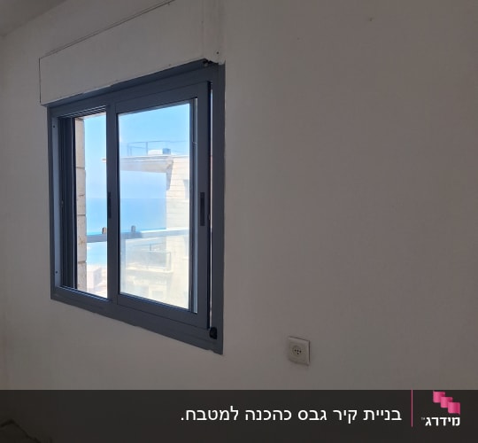 סינר גבס והנמכה סביב חלון בתקרה